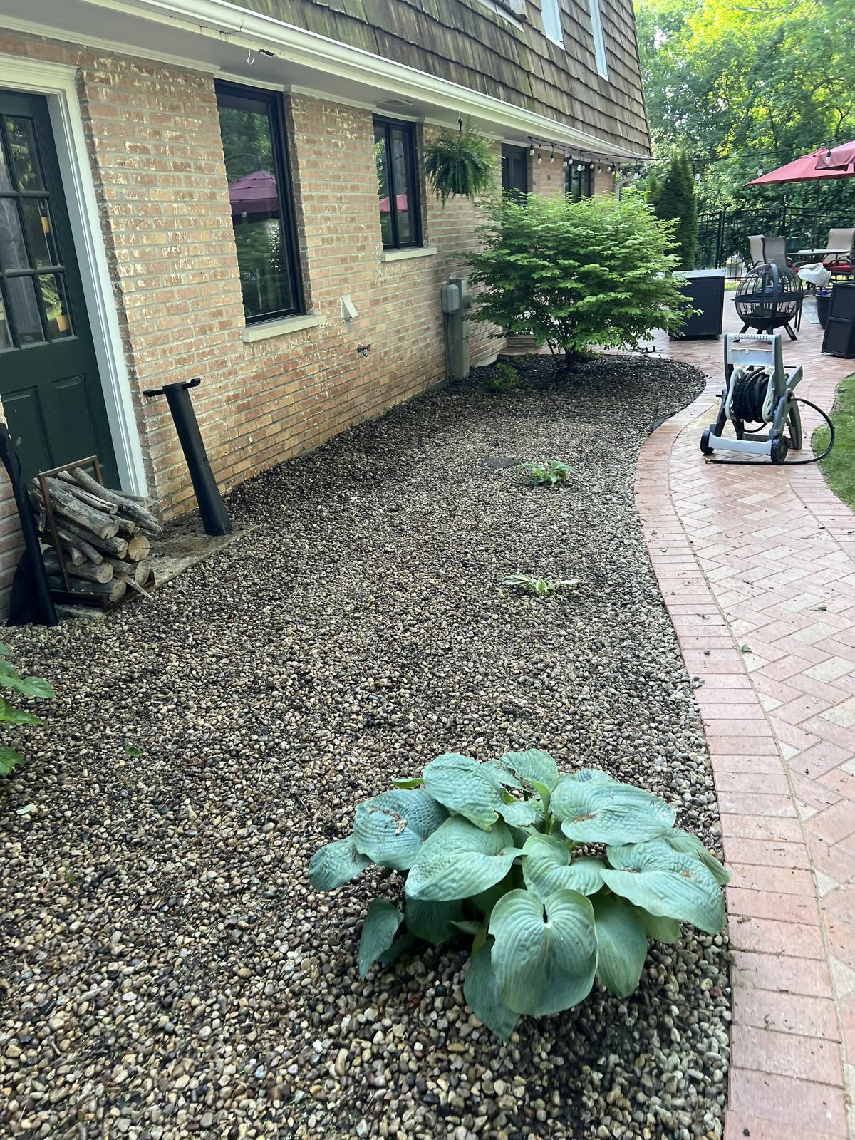 Refreshed pebble flower bed with new plantings
